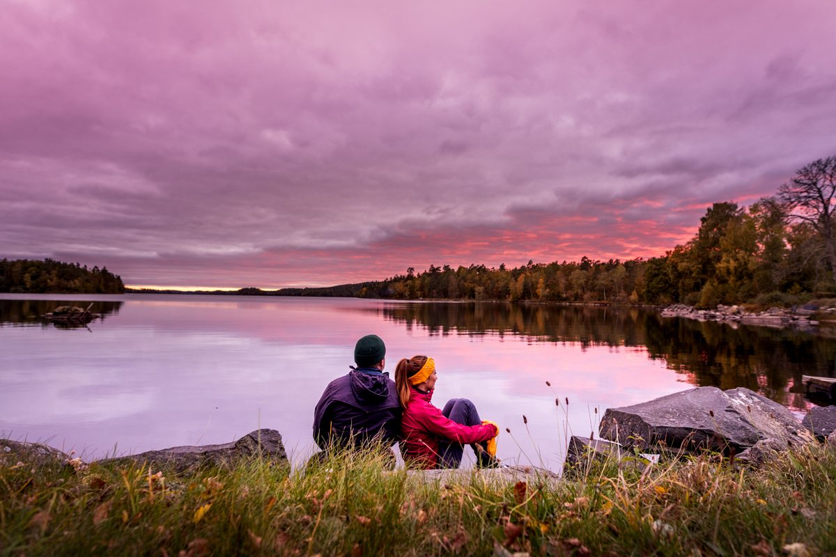 Ett par sitter intill Immeln sjön och tittar på solnedgången
