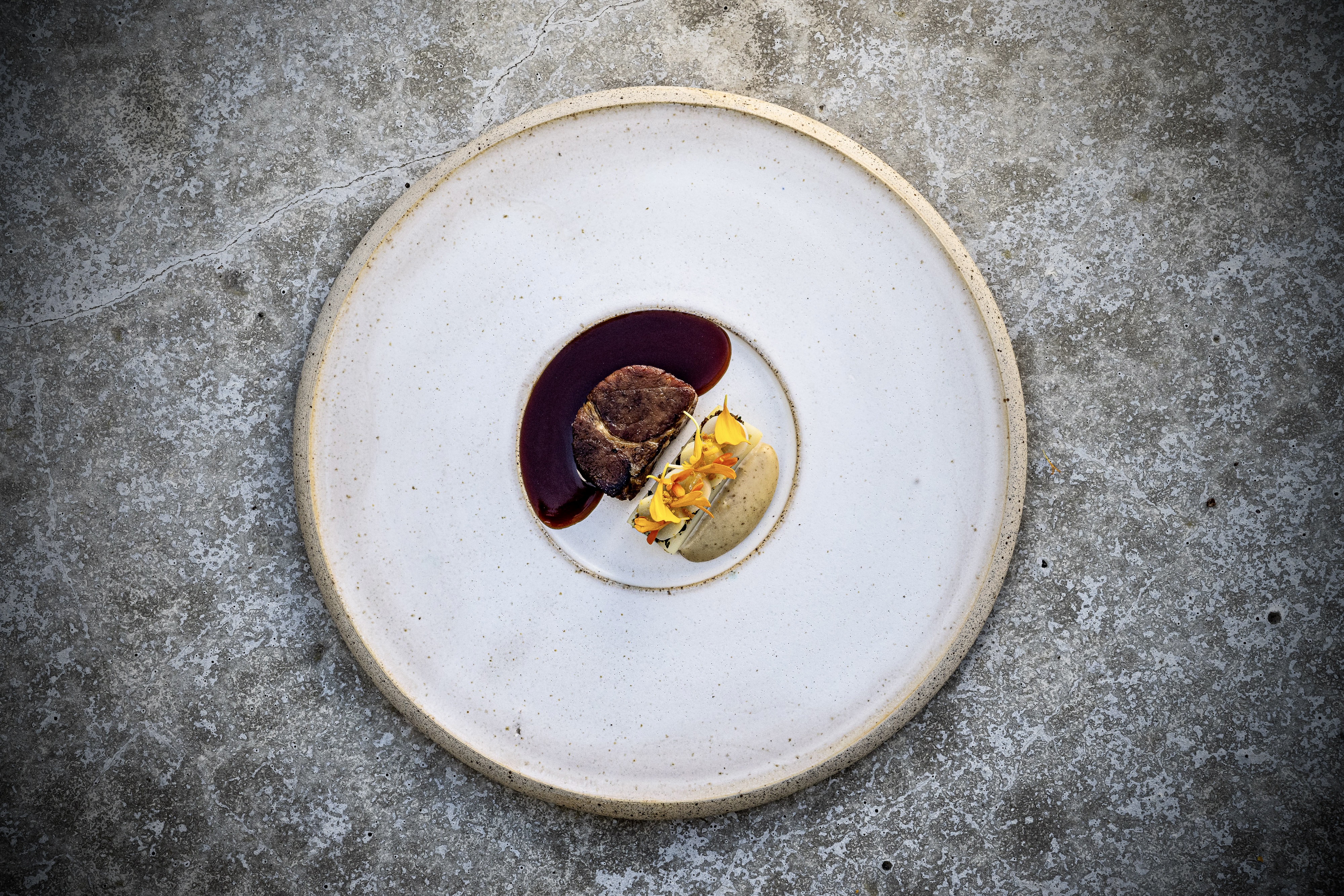 Ceramic white plate with a sophisticated meat and potato serving