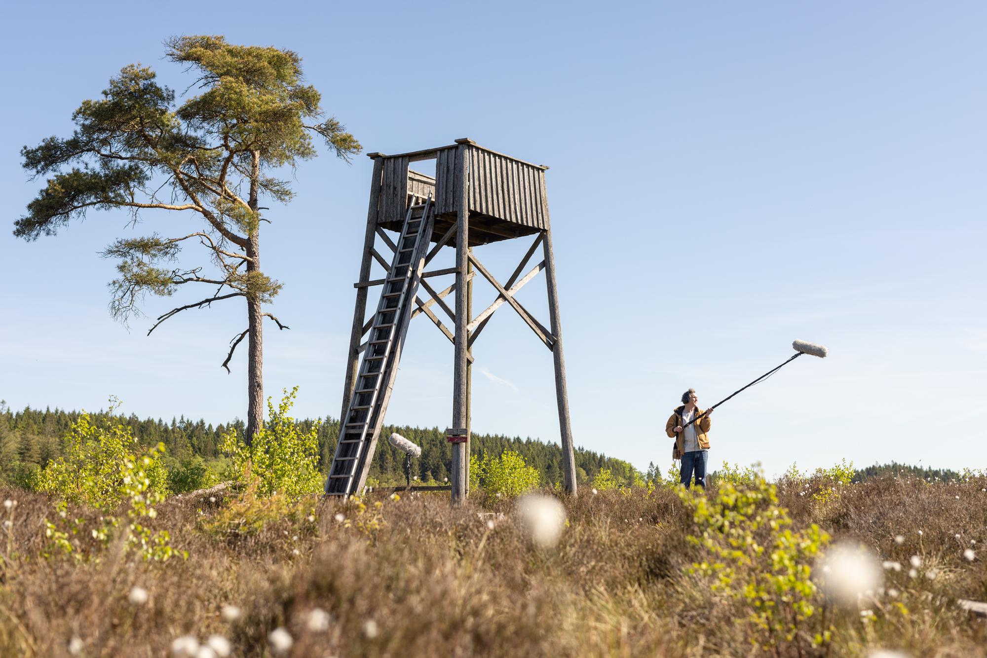 A man standing with sound boom by tower