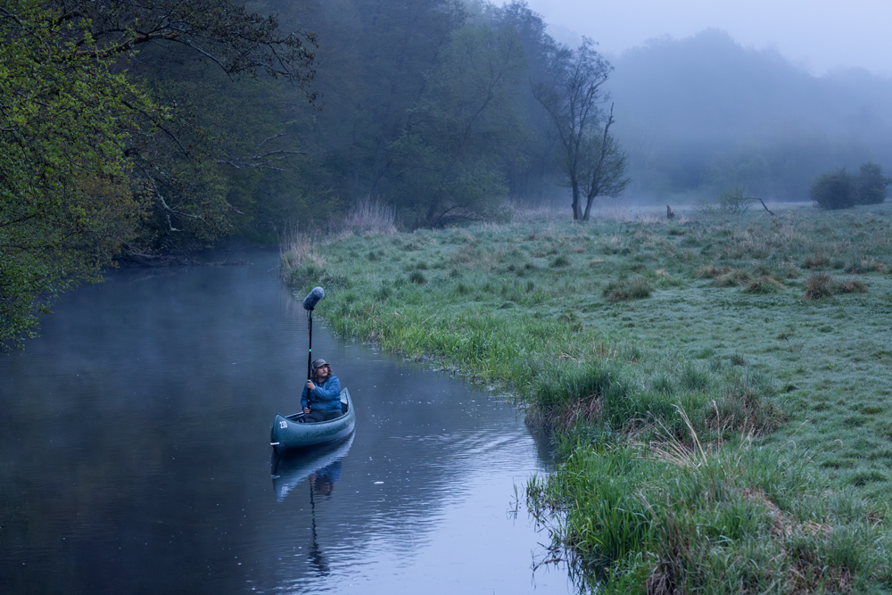 Sound guy in canoe in still Rönne river