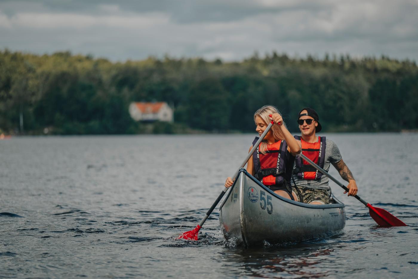 Ett ungt par paddlar kanot på sjön Immeln