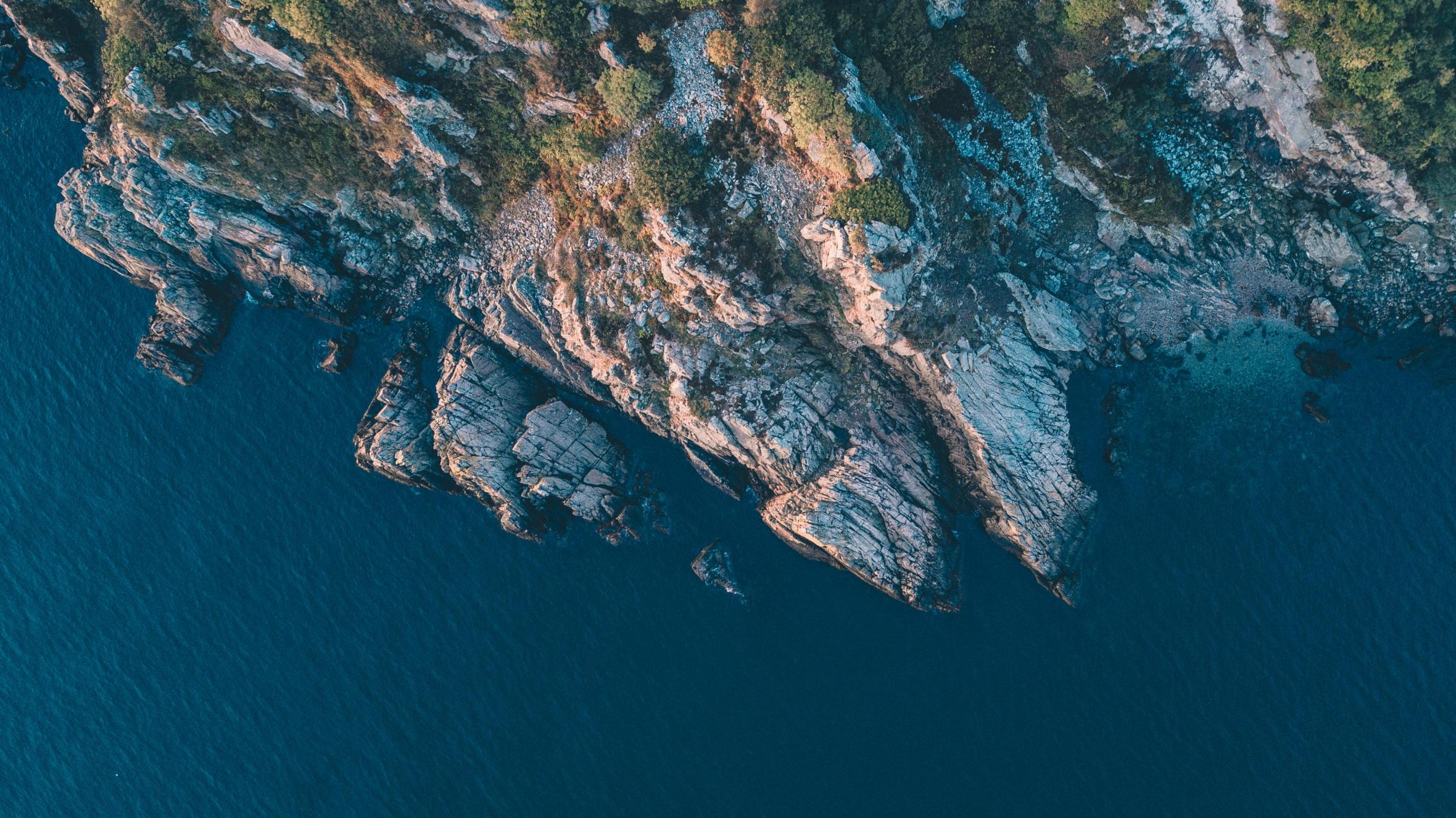 Blick von oben auf die Küste der Kullaberg-Halbinsel mit ihren Klippen und dem Meer davor.