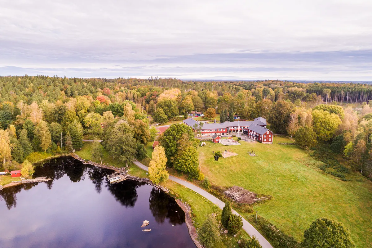 En vy ovanifrån av Brenäs hotell vid en sjö och omgiven av skog