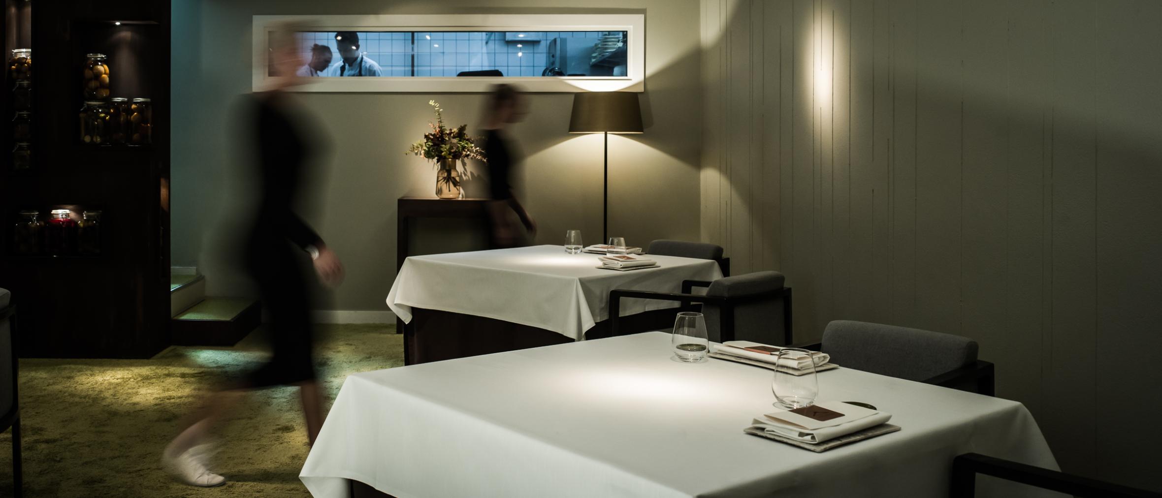 Tables with white cloths in an exklusive restaurant atmosphere