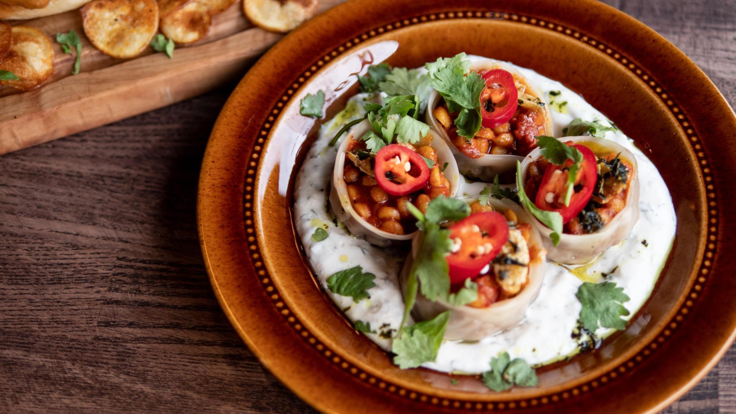 Four vegan dumplings on a ceramic plate