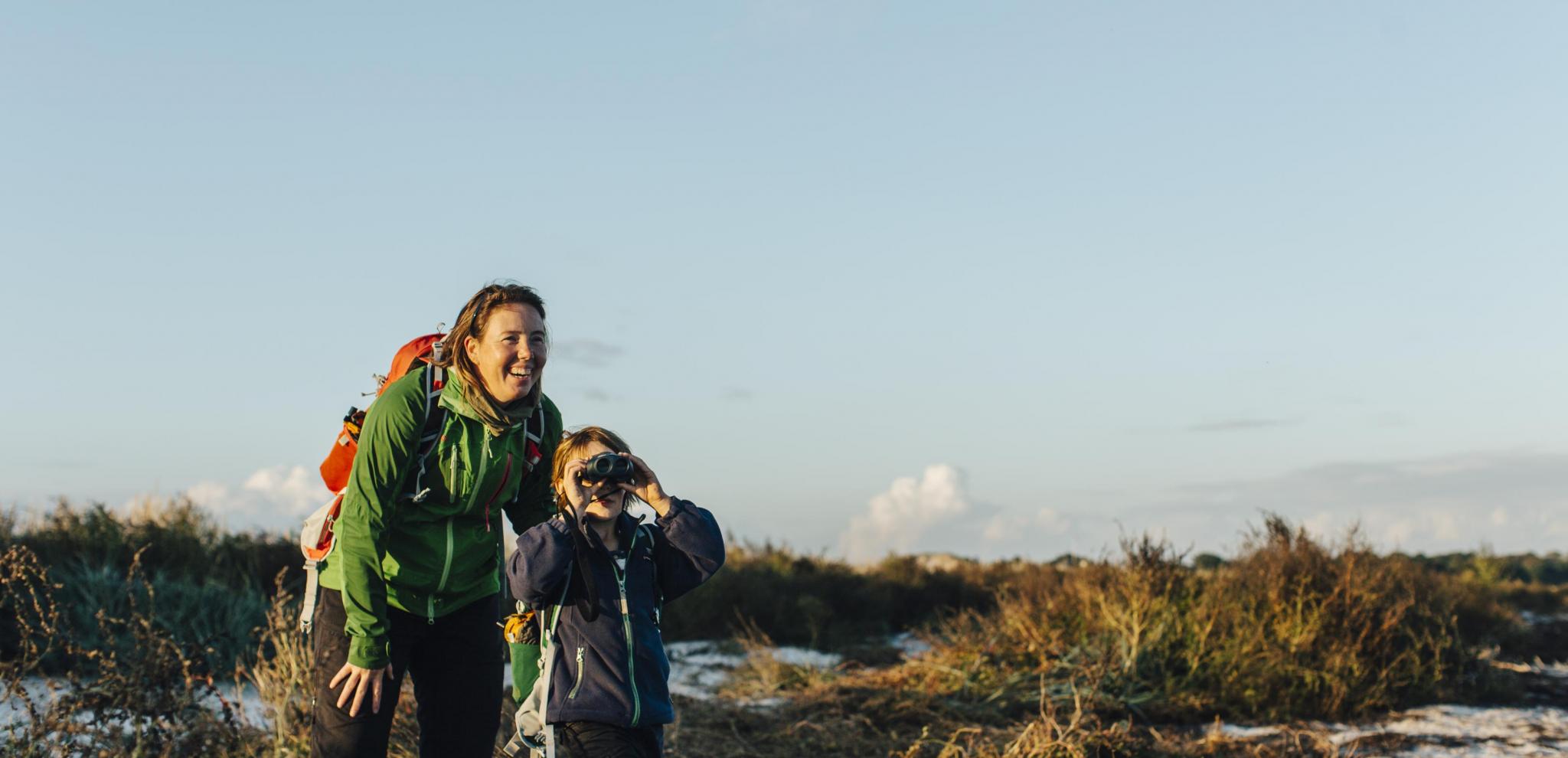 Mutter und Sohn suchen mit einem Fernglas nach Wildtieren auf der Halbinsel Måkläppen.