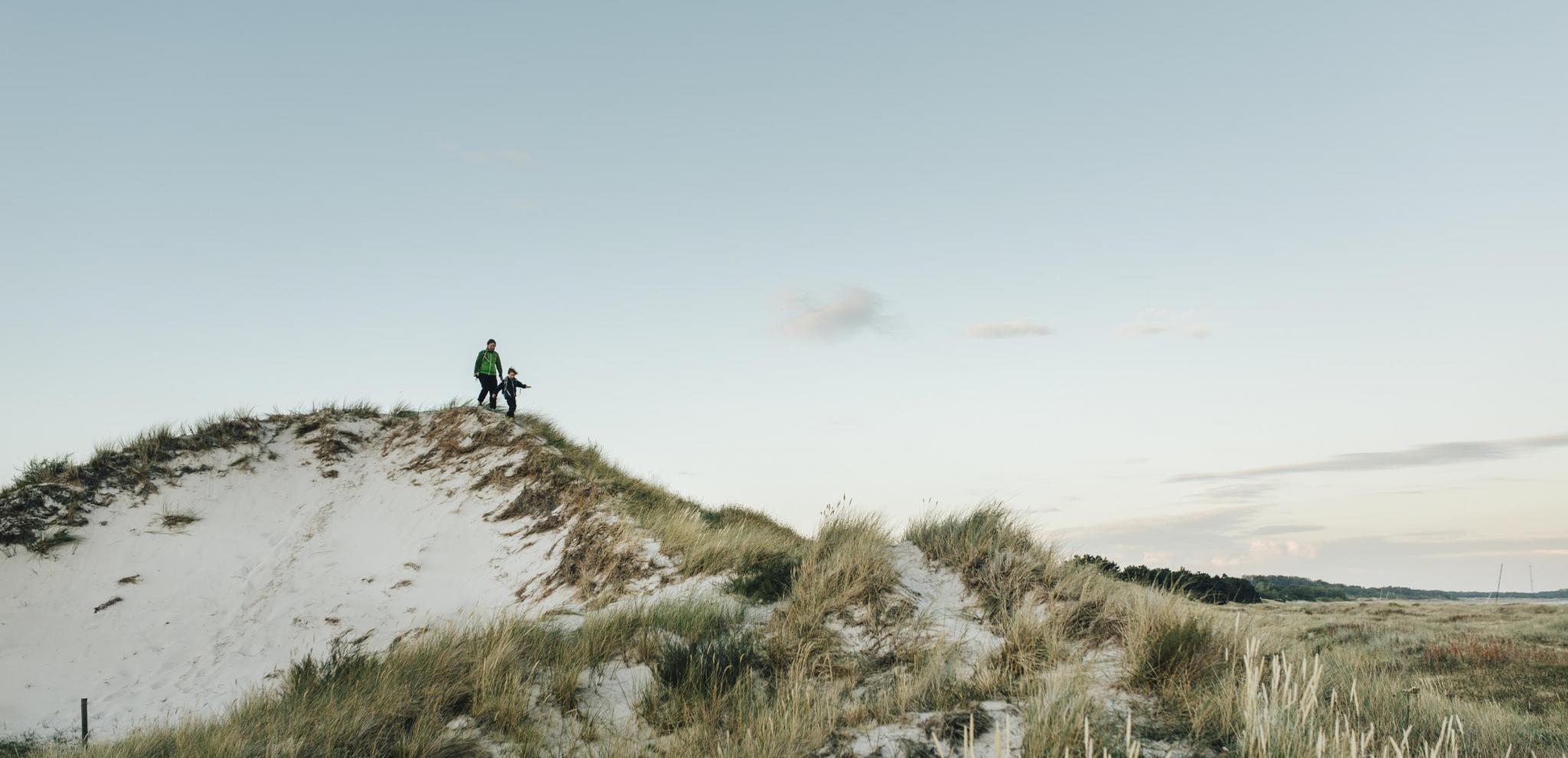 Mutter und Sohn wandern auf der Halbinsel Måkläppen über die Dünen.