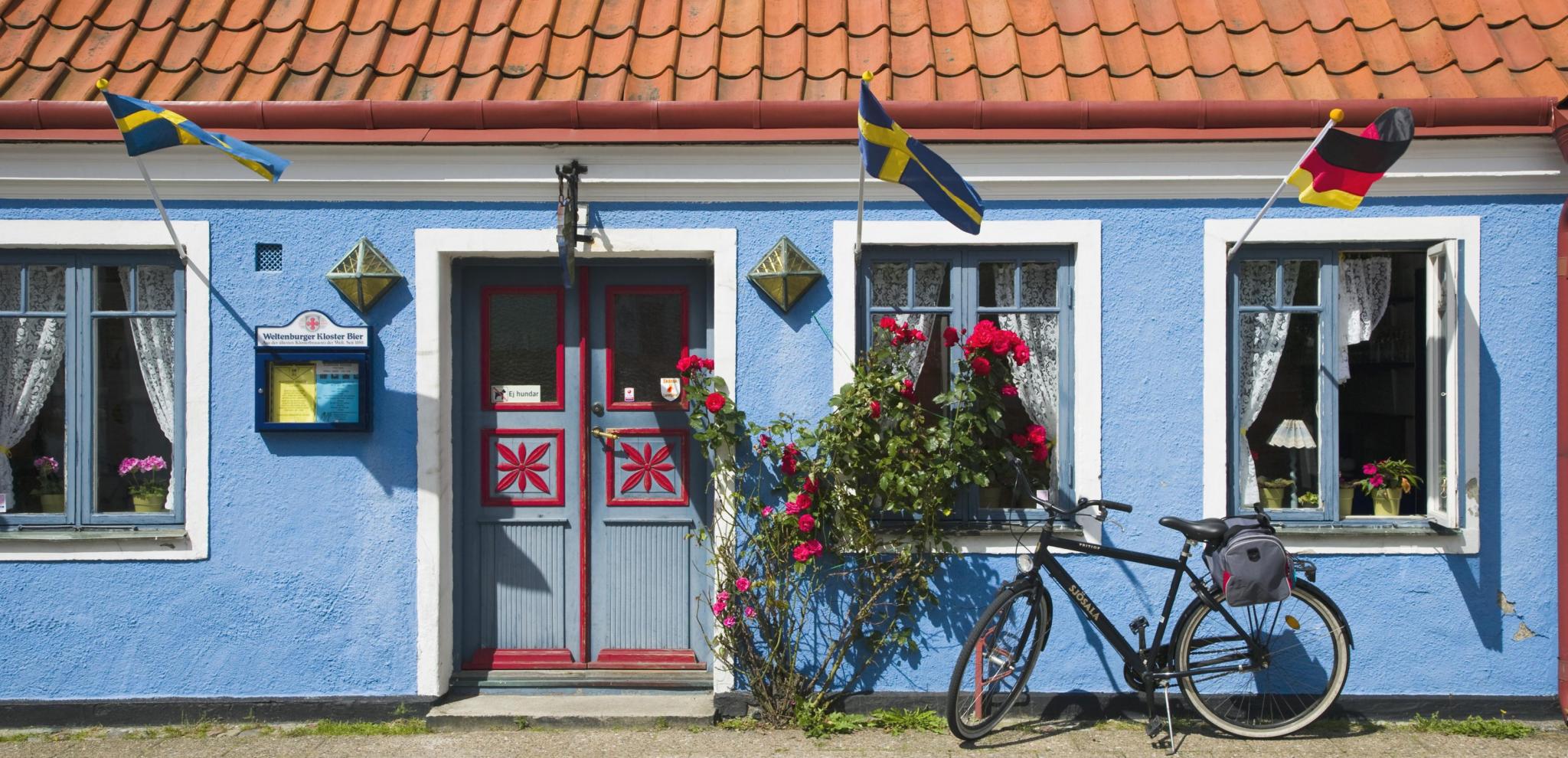 Bicycle parked outside a blue hose in Ystad 