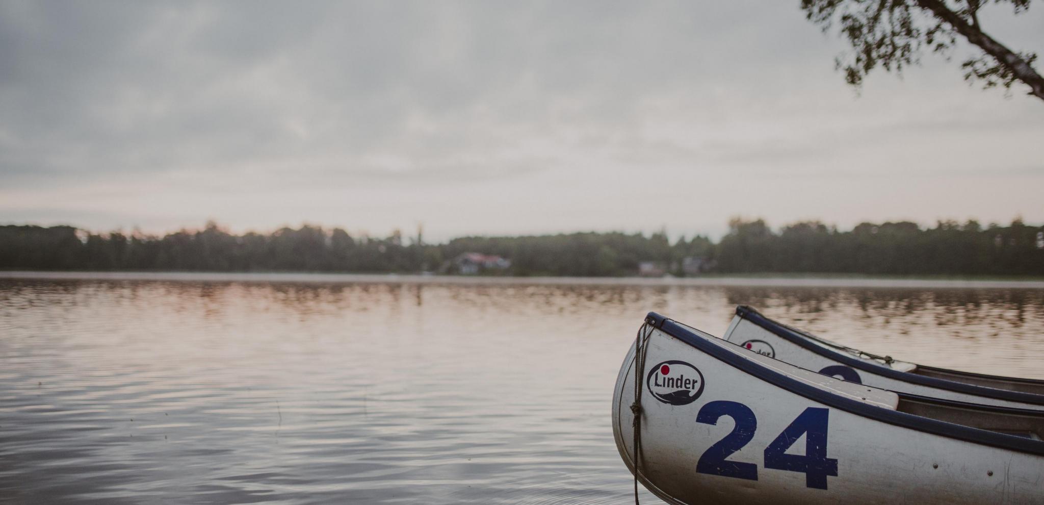 Två kanoter flyter på Ivösjön vid skymning