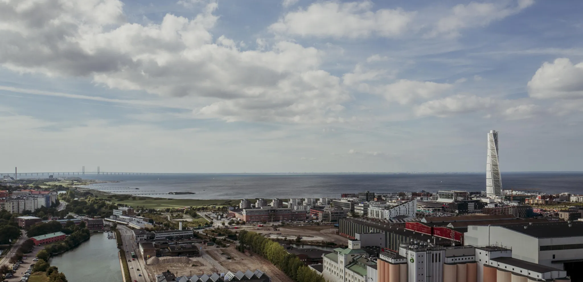 Luftbild von Malmö mit Turning Torso, Öresundbrücke und dem Meer im Hintergrund.