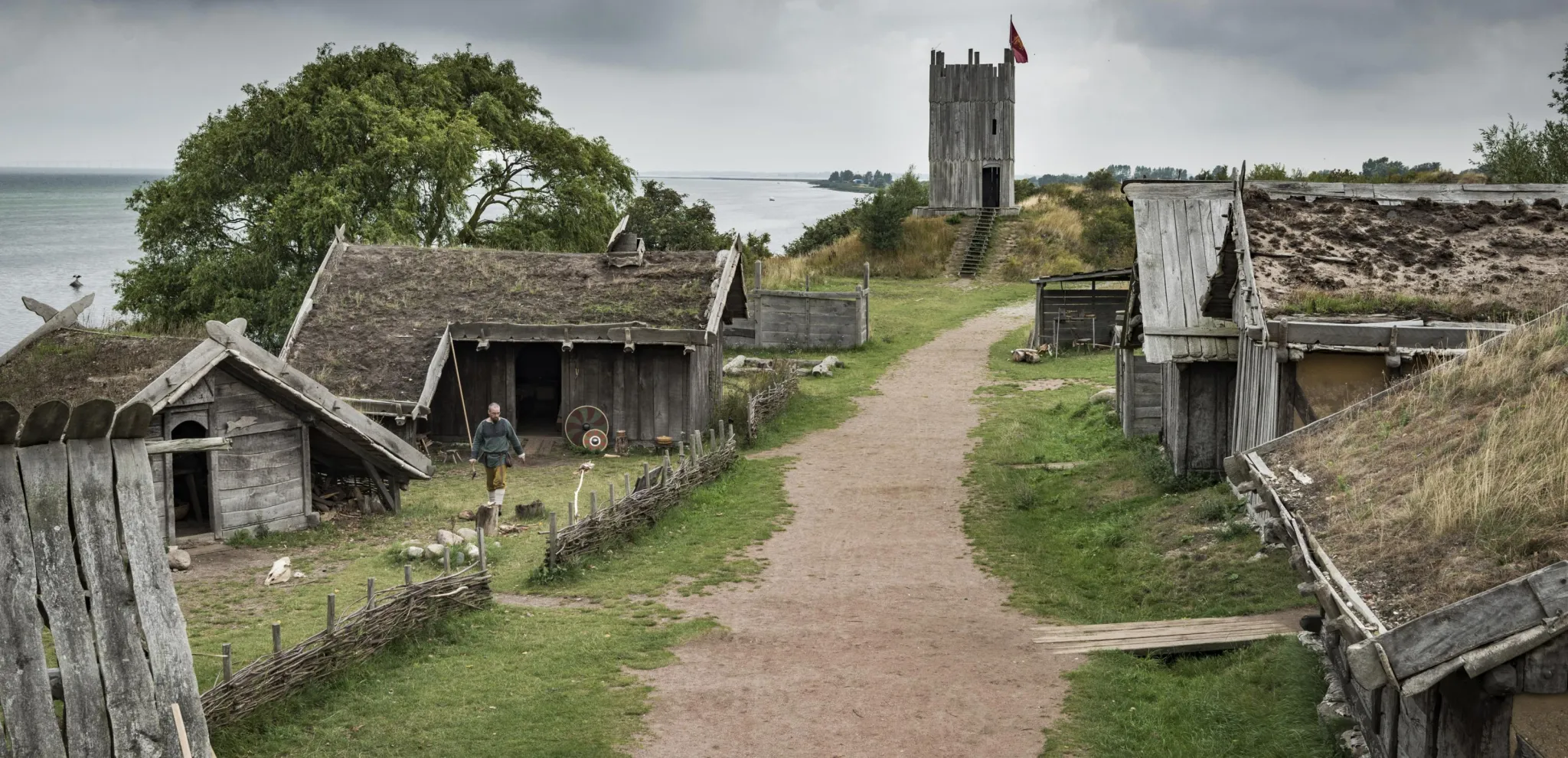 En grusväg omgiven av trähus i vikingabyn i Fotevikens Museums i Falsterbo