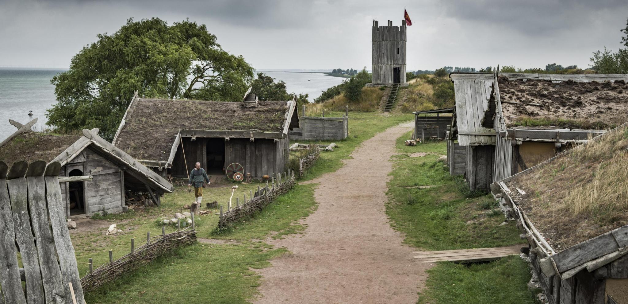 Dunkle Wolken hängen über dem Wikingerdorf Fotevikens Museums in Falsterbo, das aus zahlreichen hölzernen Gebäuden besteht.