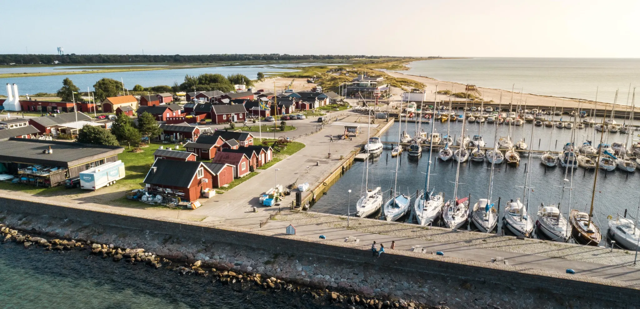 Blick von oben auf den Hafen von Skanör mit Booten und kleinen Fischerhütten.