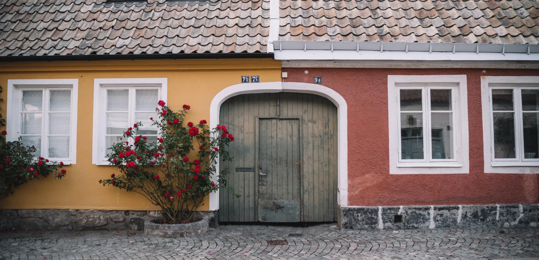  Cobblestone street with two colorful house facades