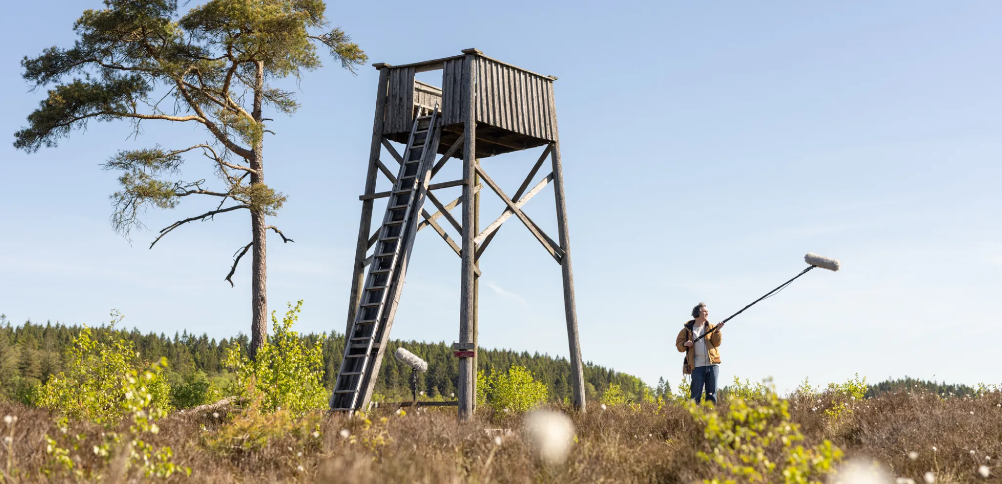 A man standing with sound boom by tower