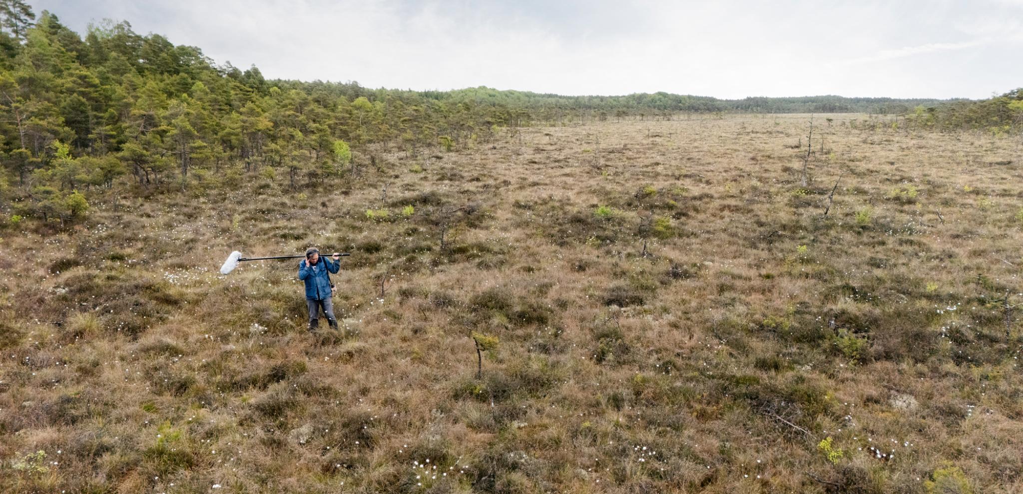A man standing on top of a grass covered field.