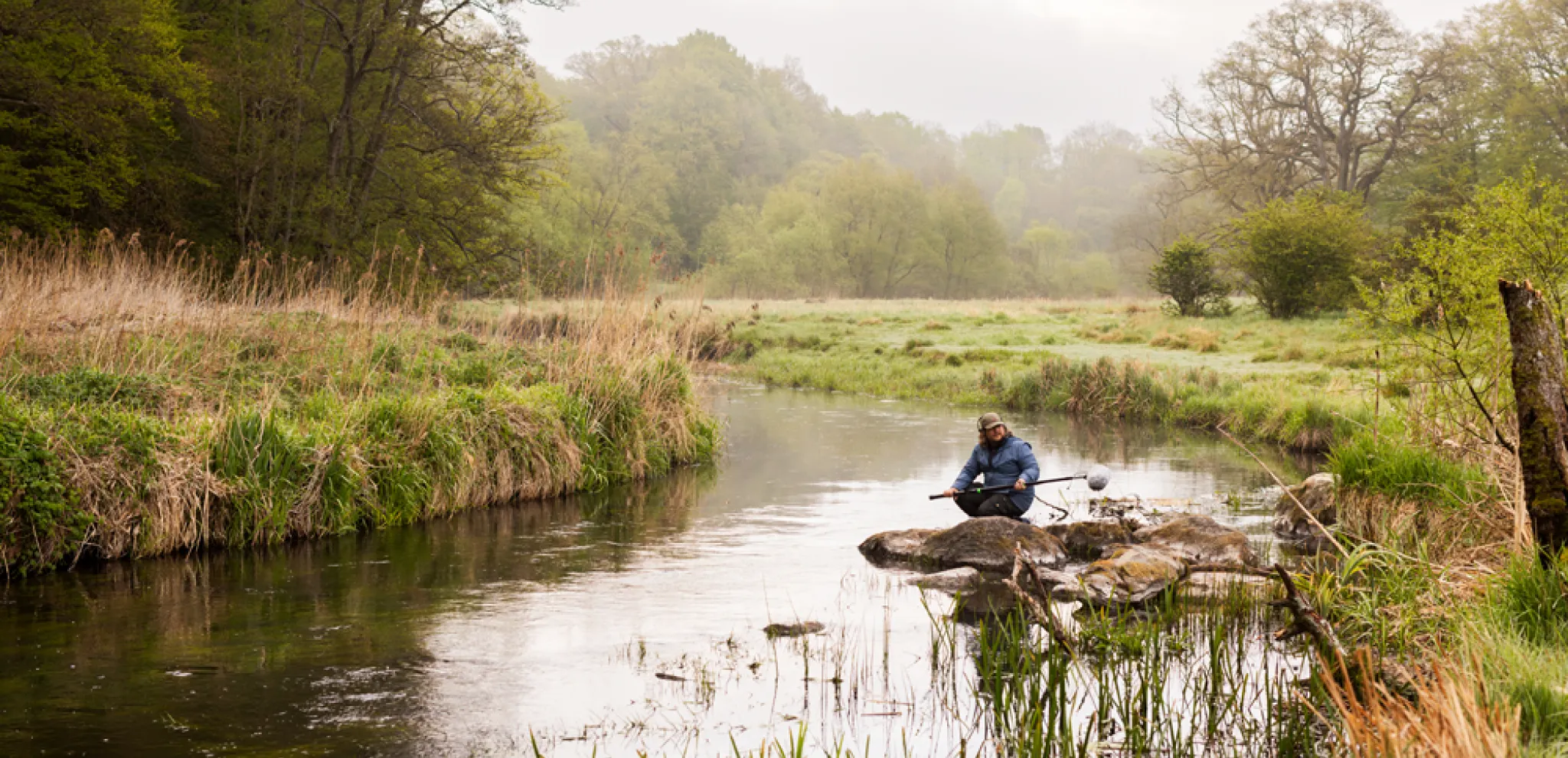 Sound guy kneeling by river