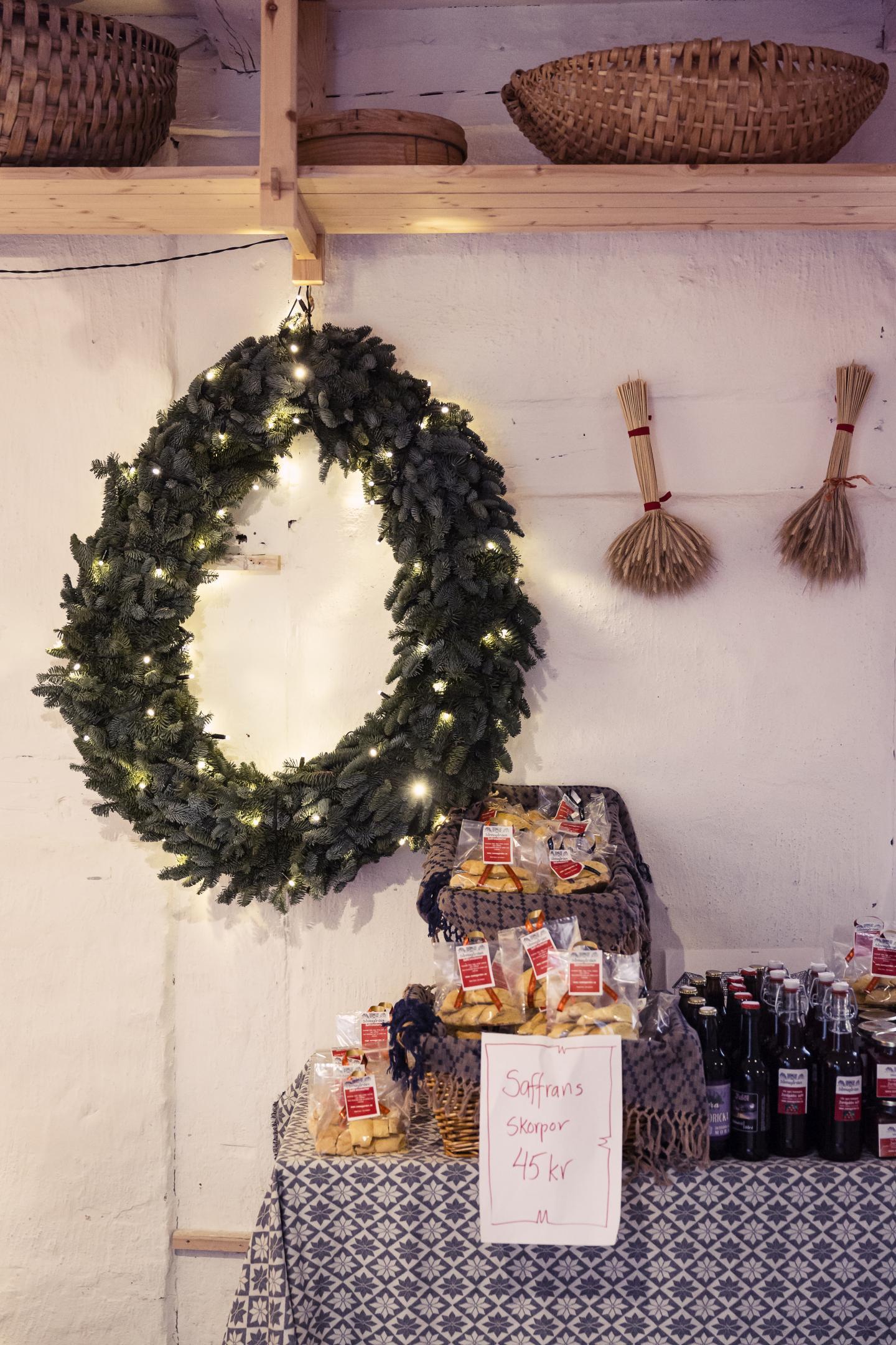 Wreath hanging above table with blue tablecloth and christmas goods