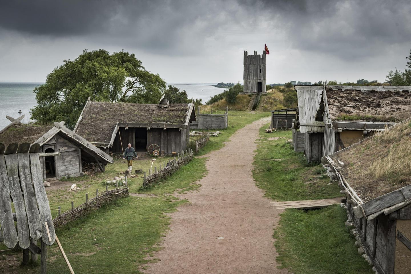 Dunkle Wolken hängen über dem Wikingerdorf Fotevikens Museums in Falsterbo, das aus zahlreichen hölzernen Gebäuden besteht.