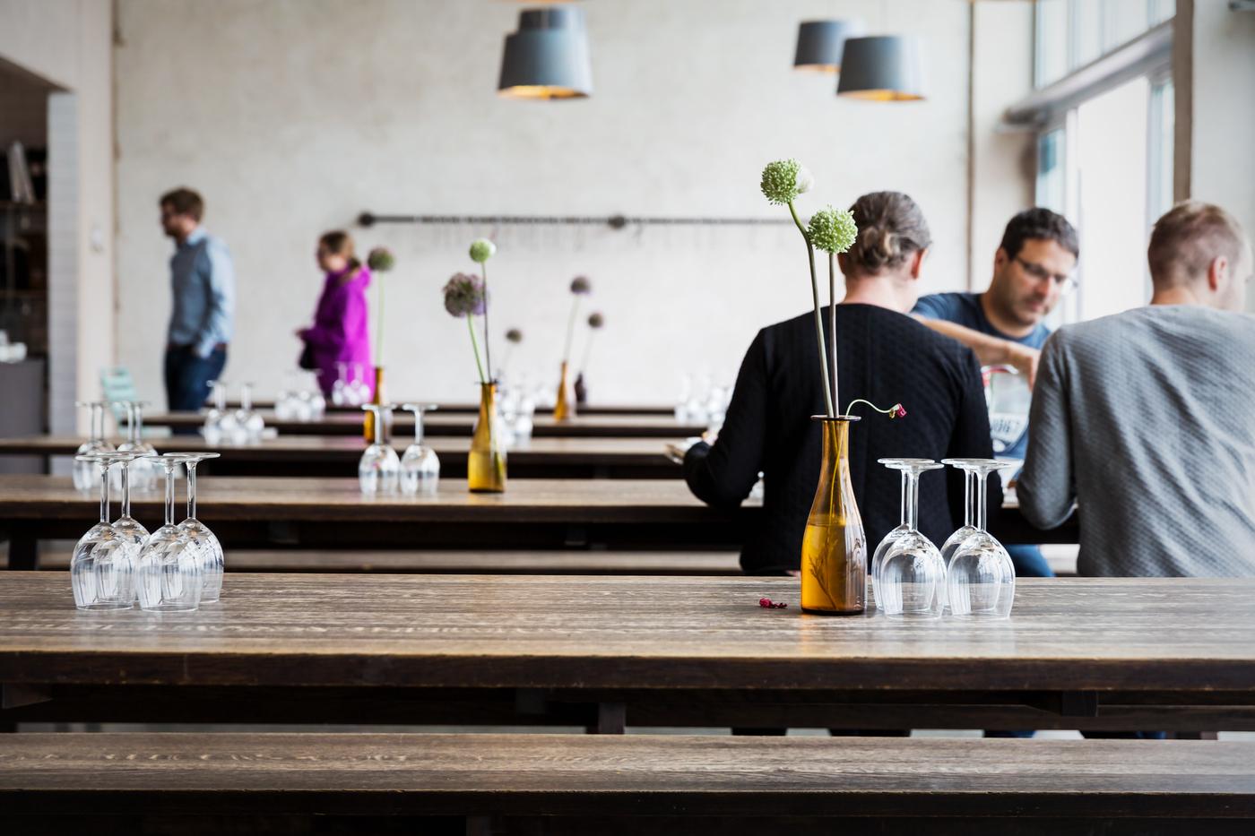 Long restaurant tables with people eating 