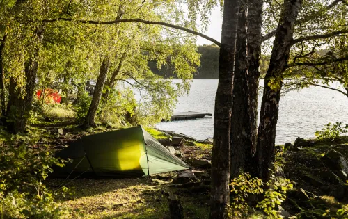 Ein grünes Zelt im Wald mit Blick auf den See Immeln.