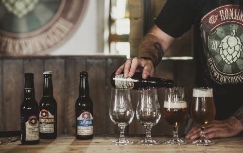 A man pouring beer into beer glasses at Hönsinge brewery