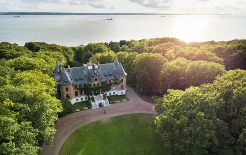 A view from above of Sofiero castle in front of the sea and souronded by trees