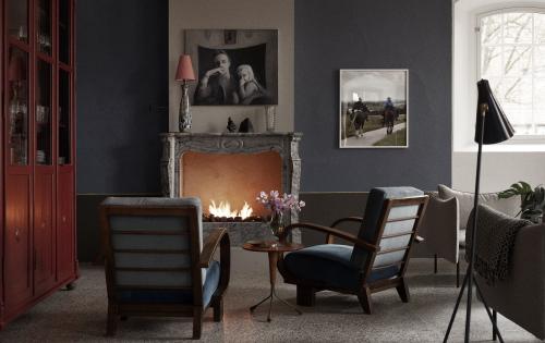 Fireplace with two armchairs positioned in front, creating a cozy lounge setting"