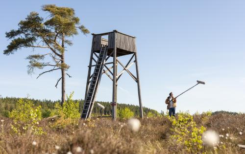 A man standing with sound boom by tower