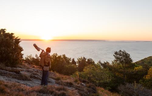 A man standing on top of a hill holding a microphone.