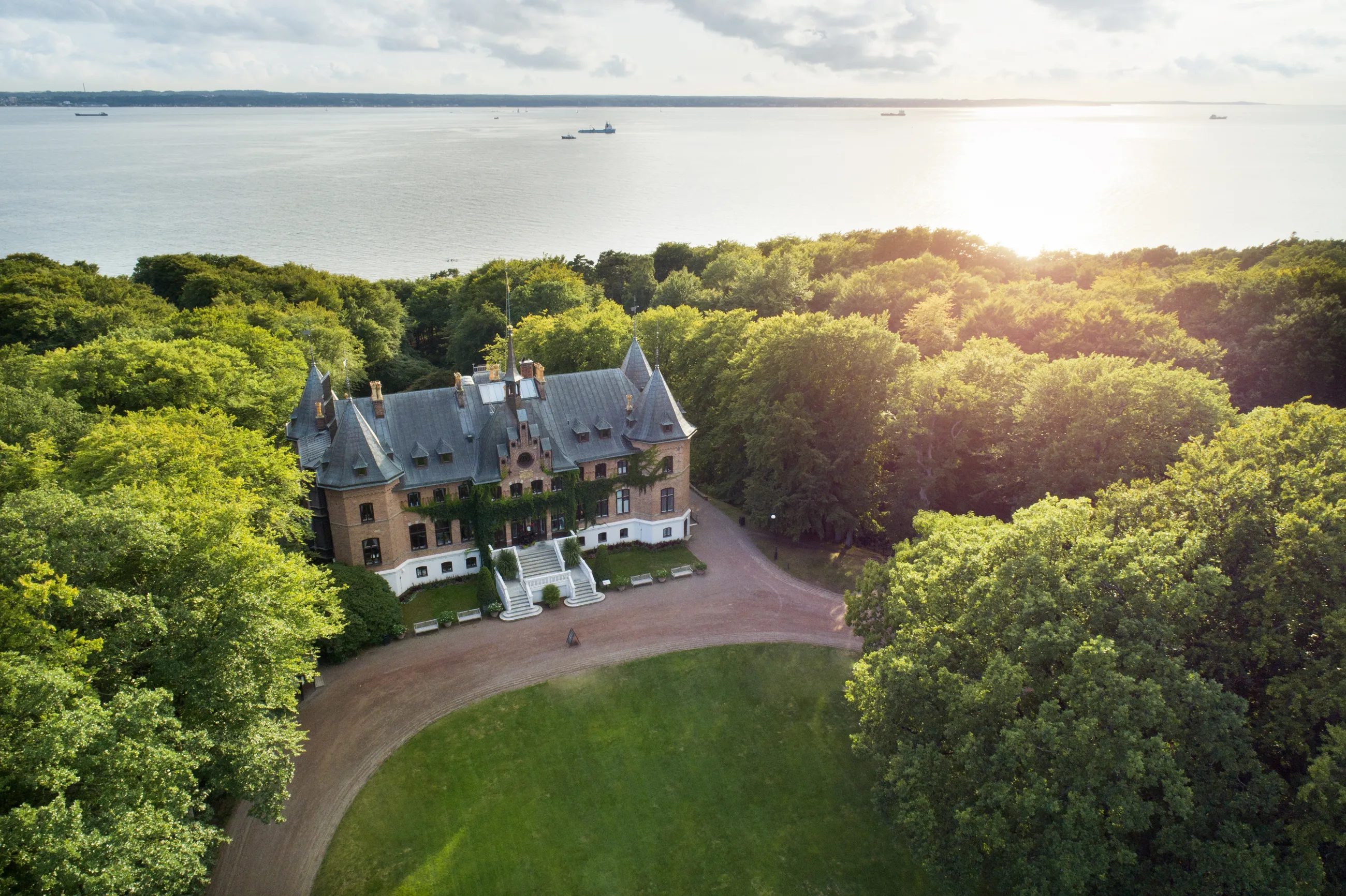 En sikt från ovan av Sofiero slott framför havet och omgiven av träd