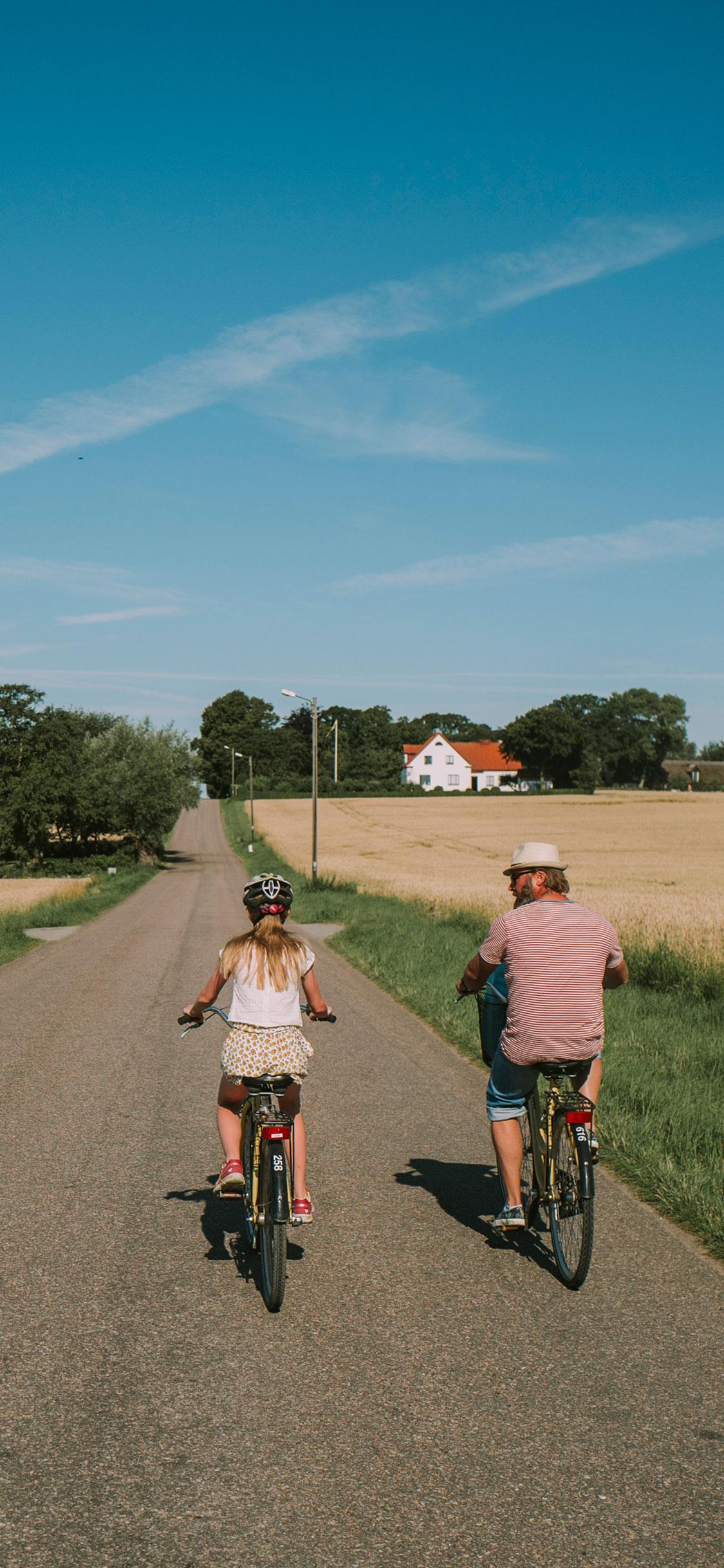 father and daughter biking on a summer day
