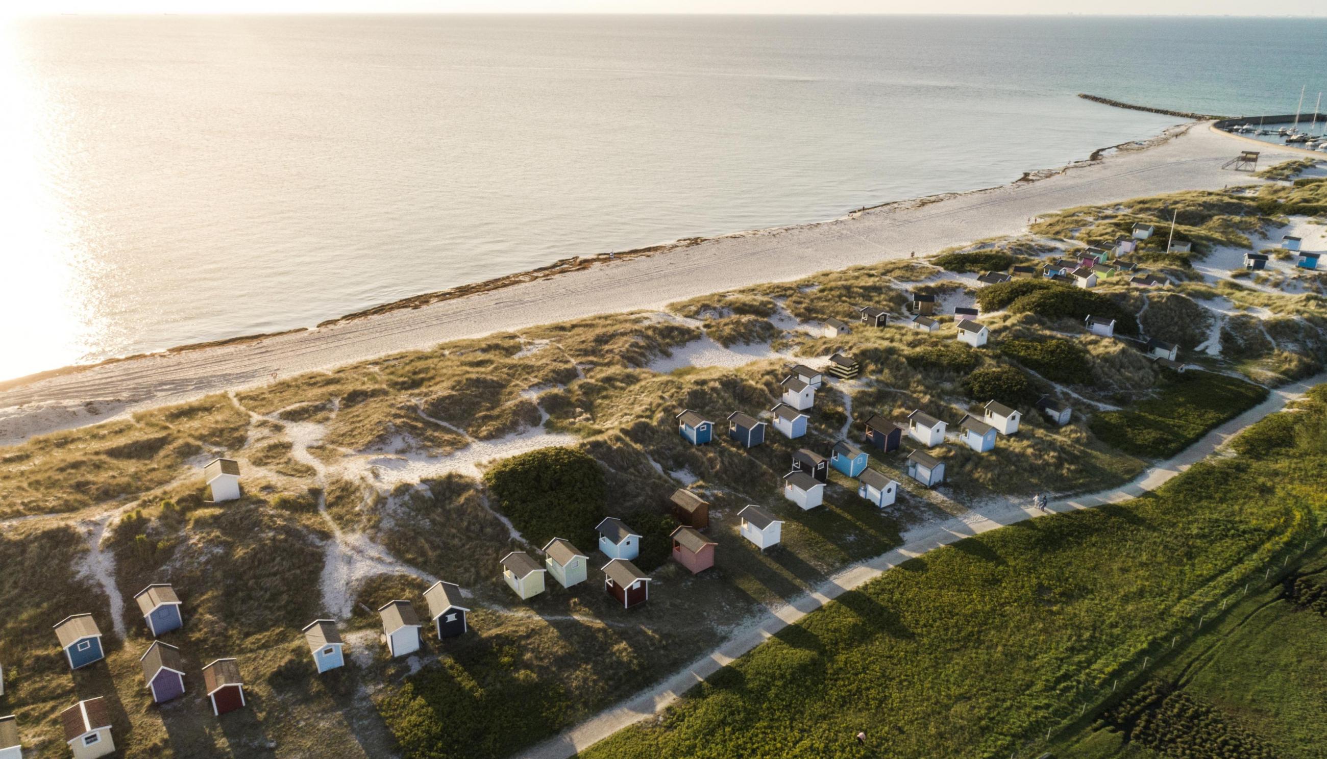 Blick von oben auf die Strandhütten von Skanör bei Sonnenaufgang.