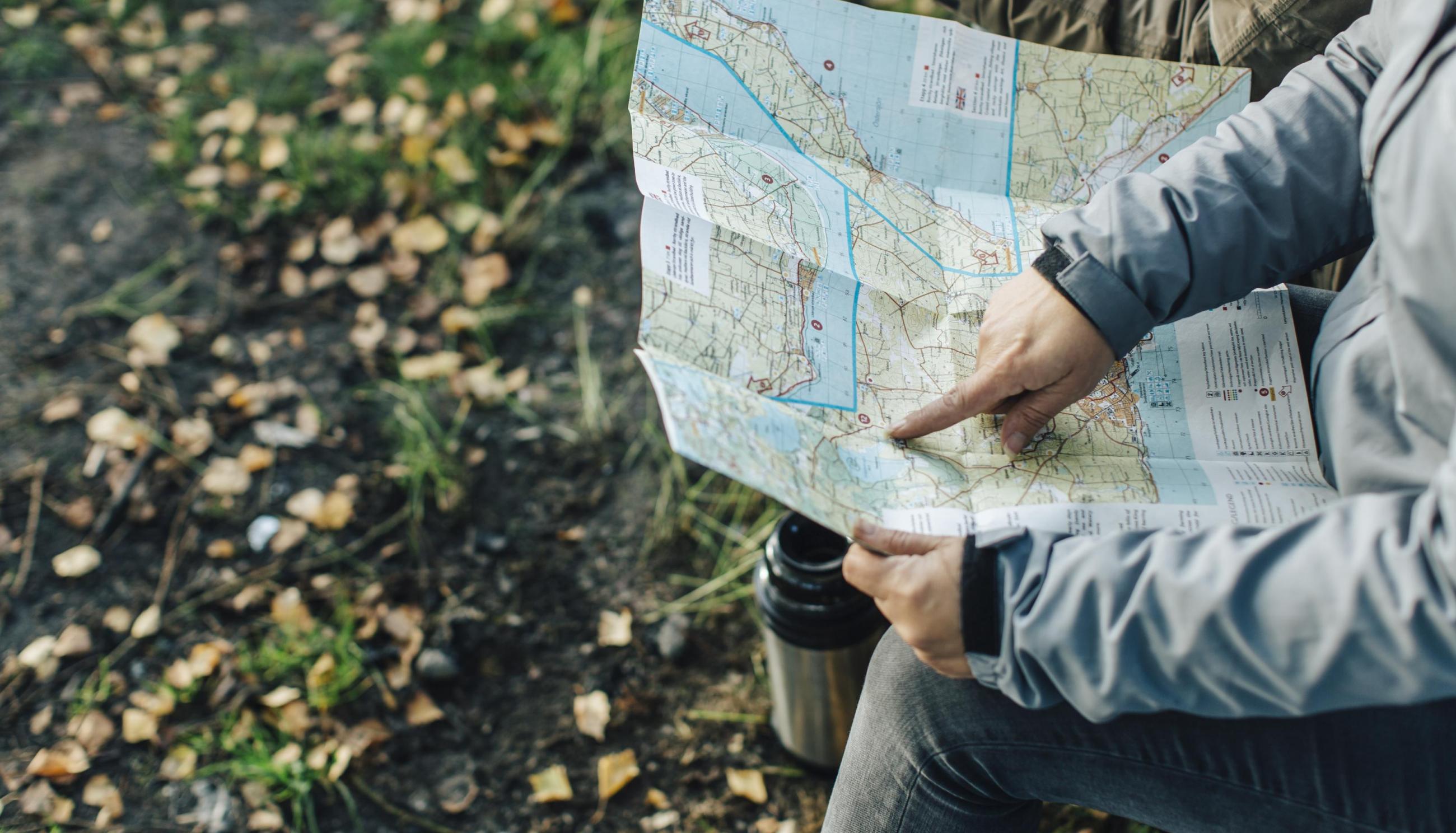 Person zeigt auf eine Karte