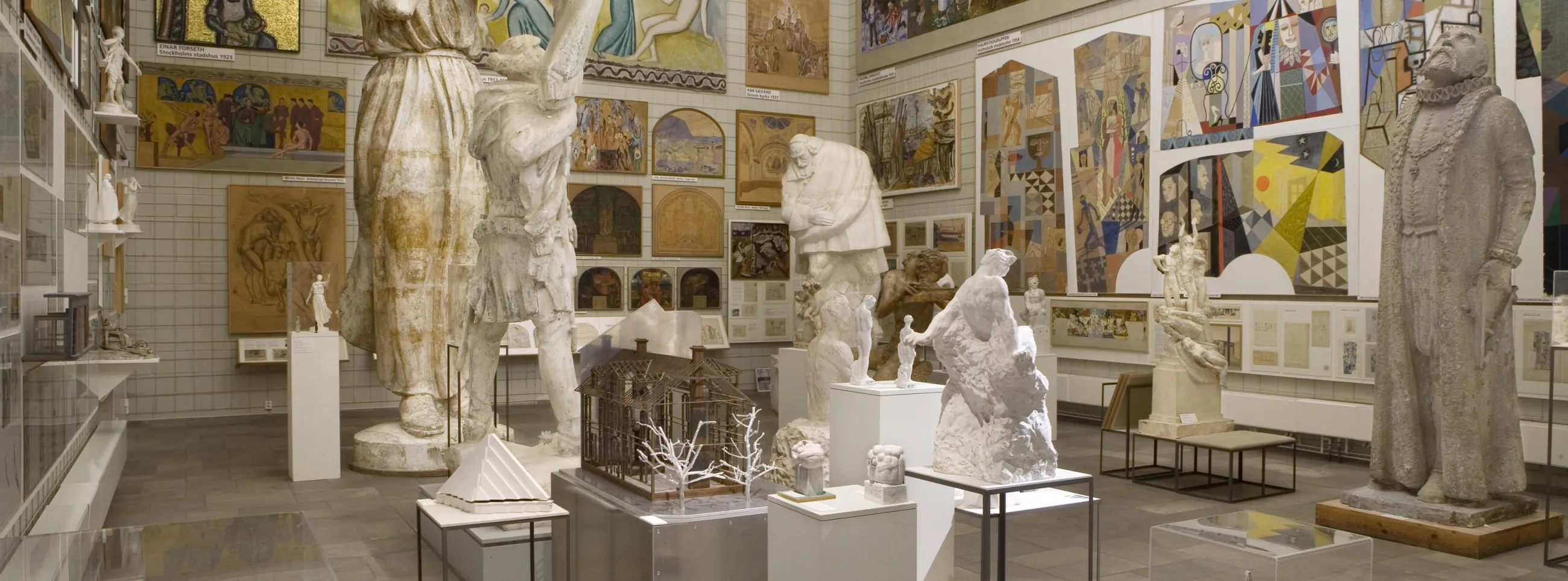 Ett rum täckt med målningar och stora antika skulpturer inuti Skissernas museum