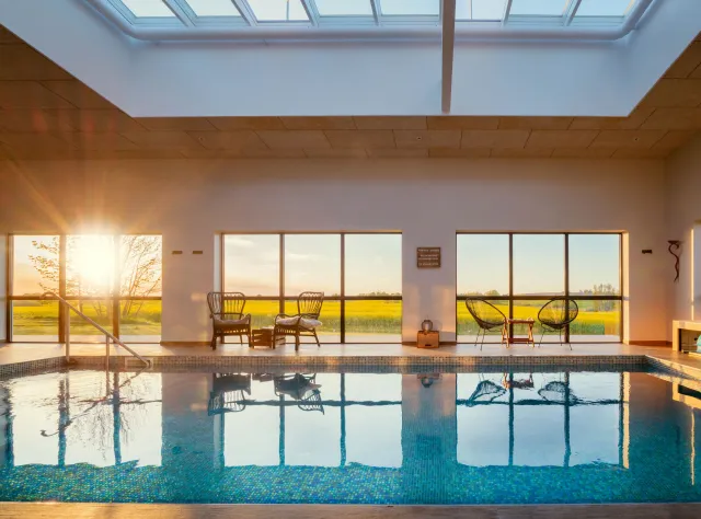 Ein Sonnenuntergang durch die Fenster des Innenpools im Hotel Mossbylund.