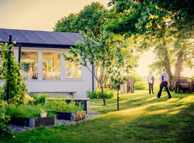 Ein Paar spaziert durch den Garten des Hotels Mossbylund.