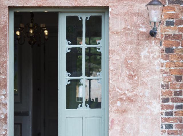 Eine rustikale graugrüne Tür, die ins Schloss Bäckaskog führt.