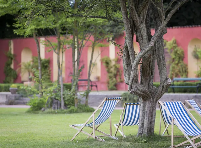 Liegestühle unter einen Baum im Garten vom Schloss Bäckaskog.
