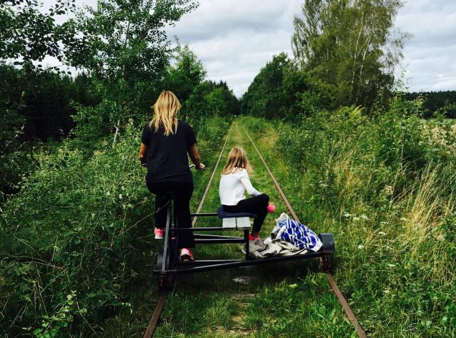 En mor och dotter dressincyklar mellan Broby -Glimminge omgivna av natur