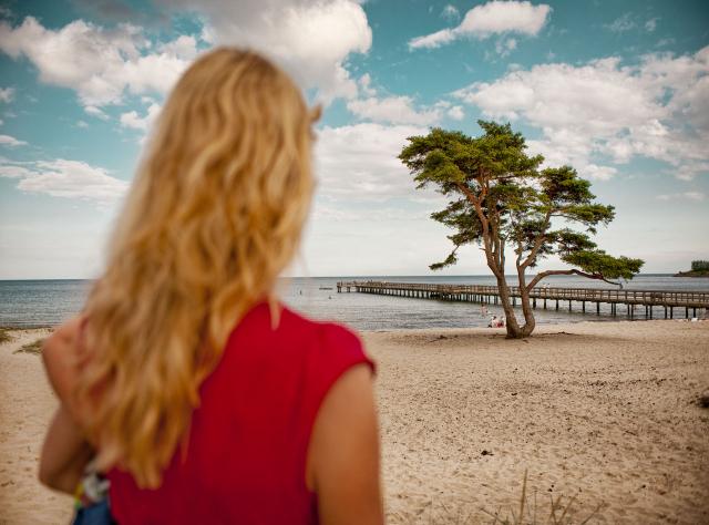 Eine Frau blickt bei Täppet in Åhus auf den Strand.
