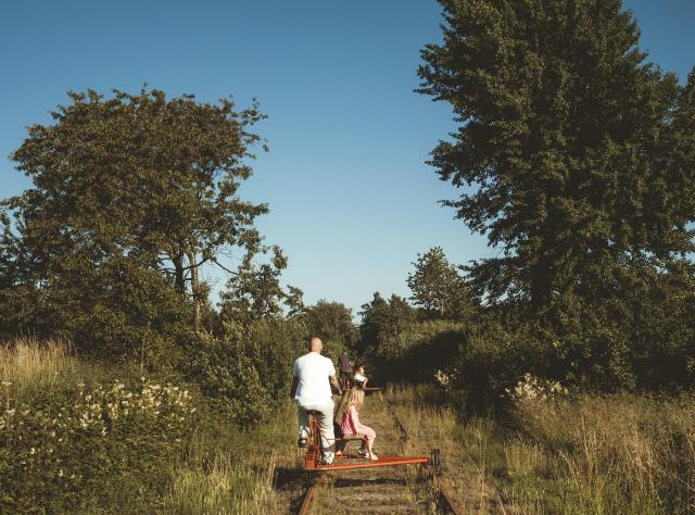 Far och dotter dressincyklar i naturen på sommaren