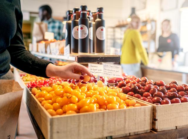 Röda och gula körsbärsröda tomater i Tomaten hus gårdsbutik