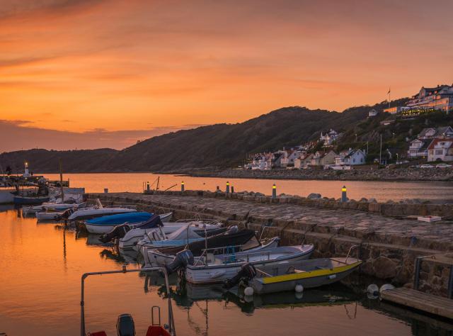 Eine Marina in der Abenddämmerung mit dem malerischen Dorf Mölle im Hintergrund.