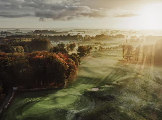 View of golf field with mist and sunshine 