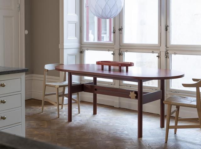 Wooden table with chairs in kitchen with large windows 