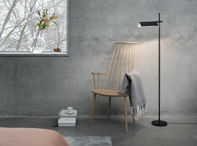 Grey room with rocking chair, blanket and a floor lamp