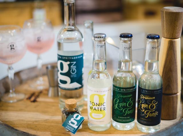 Gin and tonic bottles on a barrel