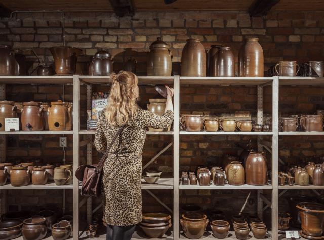 Woman browsing ceramic pots on shelves