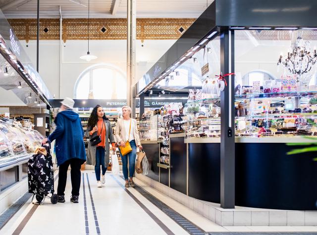 Two women shop at a grocery store. Elderly lady in the front.